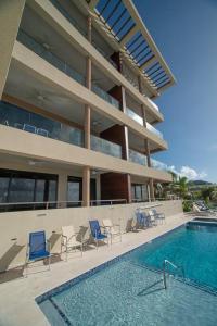 una piscina con sillas y un edificio en Luxury Ocean front SeaDreams 2 with 7 Mile Beach Views en West Bay