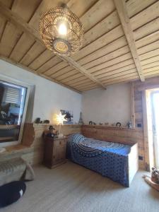 Un dormitorio con una cama grande y una lámpara de araña. en chambre atypique à 200m du lac, en Saint-Jorioz