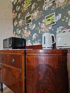 a wooden desk with two microwaves on top of it at Isla Rose Cottage in Blairgowrie