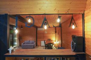 a living room with a couch and a tv at Alagi Cottage at Bazaleti lake in Grigolaantkari