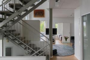 Una escalera en una casa con sala de estar en Villa Rajaportti 1st&2nd floor Loft with lakeview and free front door parking with electric car plug en Tampere