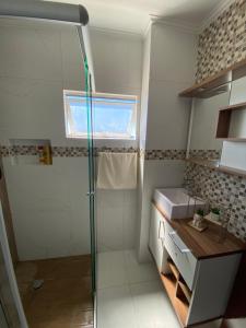 y baño con ducha y lavamanos. en Praia da Enseada - apto 3 quartos - a 100m da Praia da Enseada e a 300m da Prainha!, en São Francisco do Sul