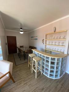 cocina y comedor con barra y sillas en Praia da Enseada - apto 3 quartos - a 100m da Praia da Enseada e a 300m da Prainha!, en São Francisco do Sul