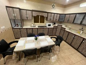 a dining room with a table and chairs and a kitchen at شقةكبيره 4 غرف منها 3 غرف نوم اطلاه مجلس صالة 4-room apartment, including 3 bedrooms, a living room, a sitting room, and a view in Taif