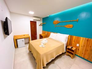 een kleine kamer met een bed en een televisie bij Pousada Villa Marceneiro Beach in Passo de Camarajibe