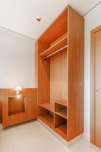 a walk in closet with wooden cabinets and a light at Salinas Exclusive Resort in Salinópolis