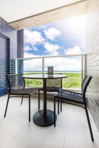 a table and two chairs on a balcony with a laptop at Salinas Exclusive Resort in Salinópolis