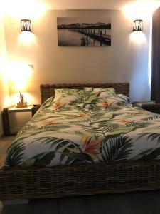 een slaapkamer met een bed met een deken met bladeren bij Les Balusets in Vinezac