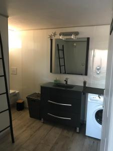 a bathroom with a sink and a washing machine at Les Balusets in Vinezac