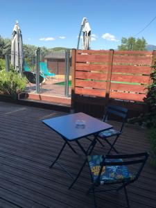 een tafel en twee stoelen op een terras met een speeltuin bij Les Balusets in Vinezac