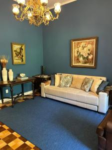 uma sala de estar com um sofá e um lustre em Requinte e Conforto Palácio Quitandinha em Petrópolis