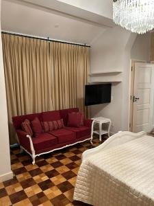 uma sala de estar com um sofá vermelho e uma cama em Requinte e Conforto Palácio Quitandinha em Petrópolis