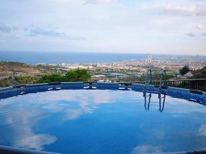 a large swimming pool with a view of a city at A+View Private Terrace Private Pool Family Fun in Badalona