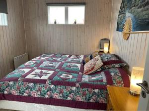 1 dormitorio con 1 cama con edredón en Nice whole year Cottage byThingvallavatn, en Veiðilundur