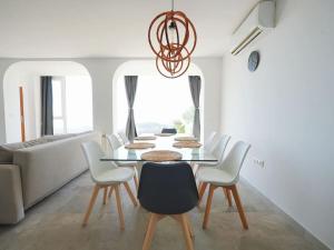 a dining room with a table and white chairs at A+View Private Terrace Private Pool Family Fun in Badalona