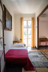 Un dormitorio con una cama con una manta roja y una ventana. en The Chandelier, en Génova