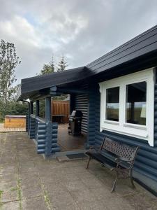 a blue house with a bench in front of it at Luxury cottage located in the Golden Circle, mountain view! in Laugarvatn