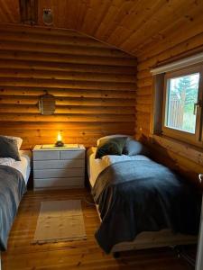 una camera con 2 letti su una parete in legno di Luxury cottage located in the Golden Circle, mountain view! a Laugarvatn