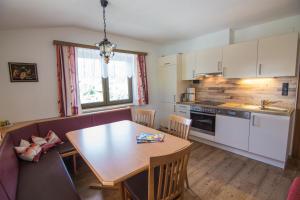 a kitchen with a wooden table and a dining room at Appartmenthaus Martina in Zell am Ziller