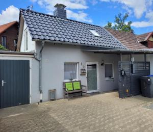 une maison blanche avec un banc dans la cour avant dans l'établissement Ferienhaus kleine Remise, à Langelsheim