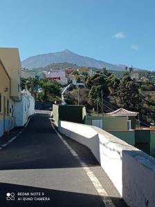 una calle vacía en una ciudad con montañas en el fondo en 2Faros, en La Guancha