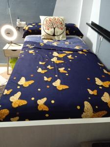 Una cama con un edredón azul con hojas. en Ikigai House, en Sevilla