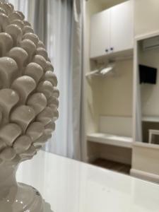 a white vase sitting on top of a counter with a refrigerator at Ines bed and breakfast & Apartments in Giardini Naxos