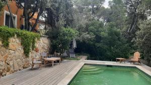 a swimming pool with chairs and a table next to a building at Au Papillon Dort in Seillons-Source-dʼArgens