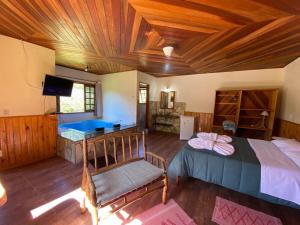 1 dormitorio con 1 cama y 1 silla en una habitación en Pousada Algama en Visconde De Maua