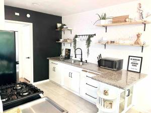 a kitchen with a counter and a sink and a stove at Beautiful Bright Condo Steps Away from the Beach in Long Beach