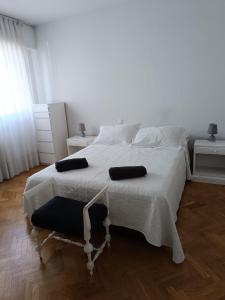 1 dormitorio con 1 cama blanca y 2 almohadas en Casa de Mirtha, en Madrid