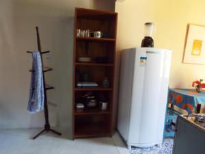 a kitchen with a white refrigerator and a shelf at Casa Manhapeba in Ilha de Boipeba