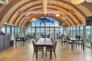 a restaurant with tables and chairs and a large room with windows at The Palms! Direct water view corner condo in Miami
