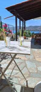 a white table with two glasses on top of it at Avli Apartments in Pyrgadikia
