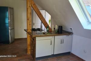 a kitchen with white cabinets and a sink in a attic at Modernes Apartment mit 3 Zimmern in Karlsruhe