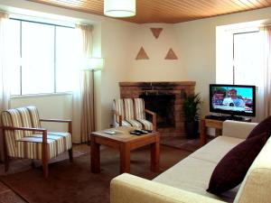 a living room with a couch and a fireplace at Oleandro Country Club in Albufeira