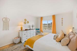 um quarto com uma grande cama branca e uma janela em Joshua Tree Sunrises and Sunsets, Hot tub, Star Gazing, Pet Friendly em Yucca Valley