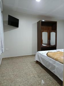 a bedroom with a bed and a flat screen tv at Dom Del'Gaudio Melhor lugar do mundo in Foz do Iguaçu