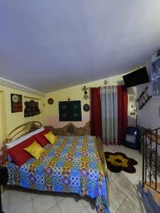 een slaapkamer met een bed met een quilt bij Punta Family House in San Giovanni la Punta