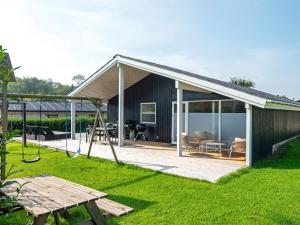 une maison avec une aire de jeux et une balançoire dans l'établissement 10 person holiday home in Juelsminde, à Sønderby