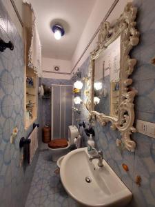 een badkamer met een wastafel, een toilet en een spiegel bij Punta Family House in San Giovanni la Punta