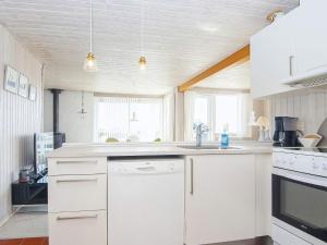 a kitchen with white cabinets and a sink at 6 person holiday home in Juelsminde in Sønderby