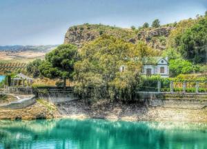una casa su una collina vicino a uno specchio d'acqua di Casa Margarita ad Ardales