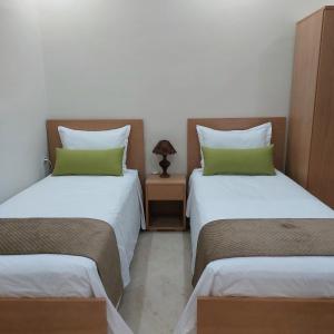 Pokój z 2 łóżkami i stołem z lampką w obiekcie Essaouira Cool apartments w mieście As-Suwajra