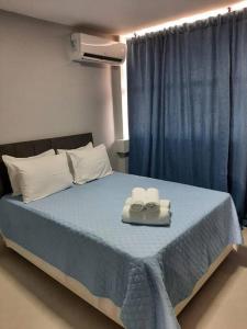 a bedroom with a bed with two towels on it at Luxo e conforto in Goiânia
