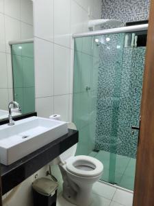 uma casa de banho com um chuveiro, um WC e um lavatório. em Serra do cipó Casa do Fábio em Santana do Riacho