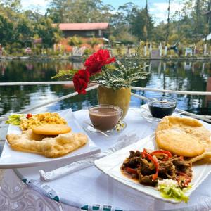 Nueva California的住宿－Cabañas Mountain River Lake Inn，一张桌子,上面放着两盘食物