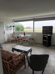 sala de estar con sofá, mesa y TV en Playa Dorada, estar y 1 dorm para 4 pers frente al mar, jardín parrilla en Santa Clara del Mar