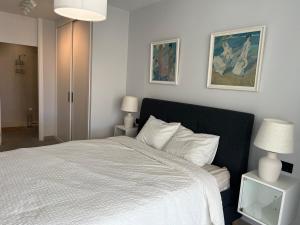 アデへにあるLas Terrazasの白いベッド1台と壁に2枚の絵が飾られたベッドルーム1室が備わります。