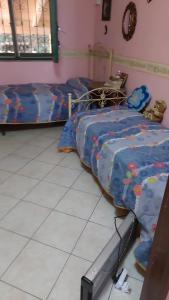 a bedroom with two beds and a tiled floor at Punta Family House in San Giovanni la Punta